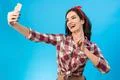 The cute woman makes a selfie on the blue background Photo