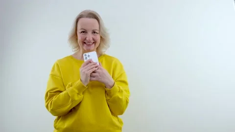 Cute woman plotting something holding a phone in her hands wants to call someone Stock Footage 234937190