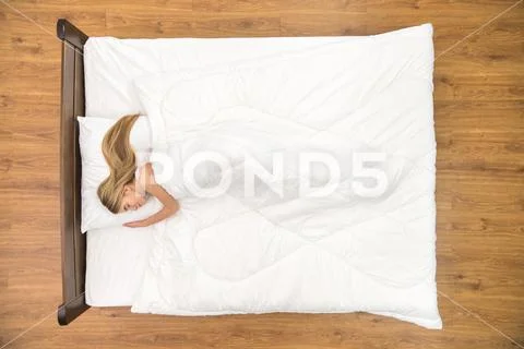 The cute woman sleeping on the bed. View from above Stock Photos