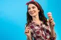 The cute woman standing with an ice cream on the blue background Photo