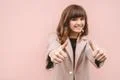 The cute woman thumbs up on the pink wall background Photo