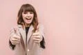 The cute woman thumbs up on the pink wall background Photo