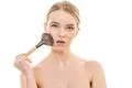The cute woman using a cosmetic brush on the white background Photo