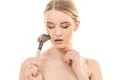 The cute woman using a cosmetic brush on the white background Photo