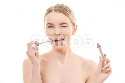 The cute woman using a lip gloss on the white background Stock Photos