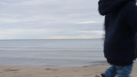 Cute young black boy chasing mother on beach 库存影片 88956044