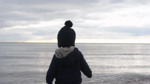 Cute young black boy throwing rock into water Stock Footage 88934243