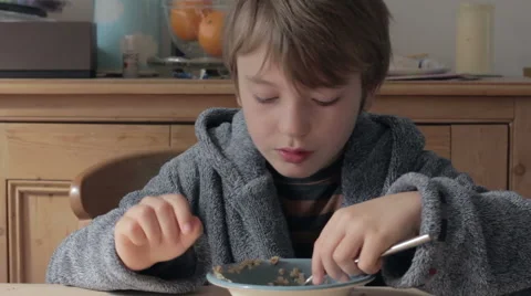 Cute young blonde boy eats porridge Stock Footage 42514022