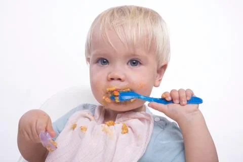 Cute young boy eating with messy face Stock Photos