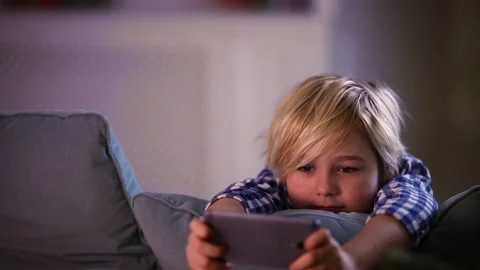 Cute young boy, kid playing games on smart phone at home Stock Footage 130447440
