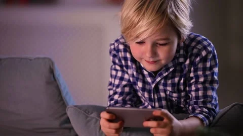 Cute young boy, kid playing games on smart phone at home Stock Footage 130447558