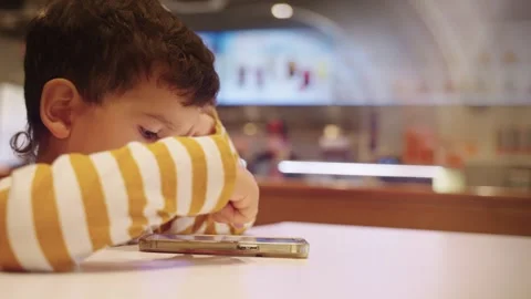 Cute Young Boy Kid Watching Cartoons on Smart Phone Stock Footage 257016228