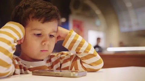 Cute Young Boy Kid Watching Cartoons on Smart Phone Stock Footage 258366215