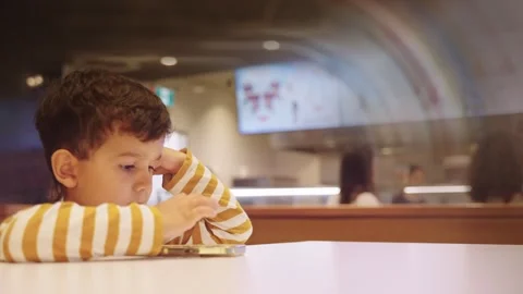 Cute Young Boy Kid Watching Cartoons on Smart Phone Stock Footage 258366289