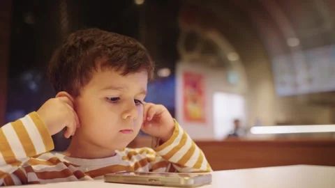 Cute Young Boy Kid Watching Cartoons on Smart Phone Stock Footage 258366525