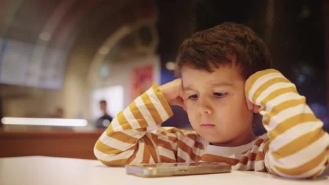 Cute Young Boy Kid Watching Cartoons on Smart Phone Stock Footage 259184516