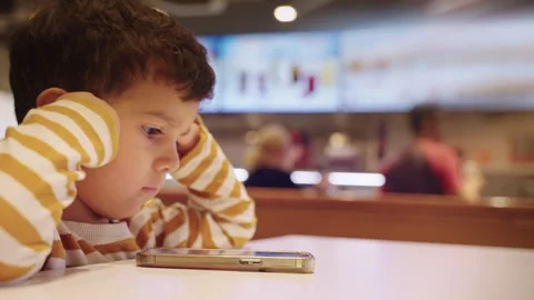 Cute Young Boy Kid Watching Cartoons on Smart Phone Stock Footage 275555992