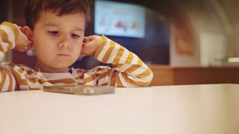 Cute Young Boy Kid Watching Cartoons on Smart Phone Stock Footage 275556179