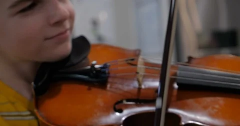 Cute young boy passionately playing the violin handheld Stock Footage 90843581