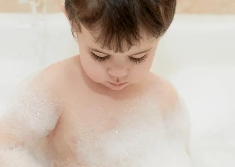Cute young boy playing with bubbles while taking a bath Stock-Fotos