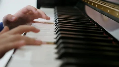 Cute young boy practices the upright piano at home Stock Footage 86545543