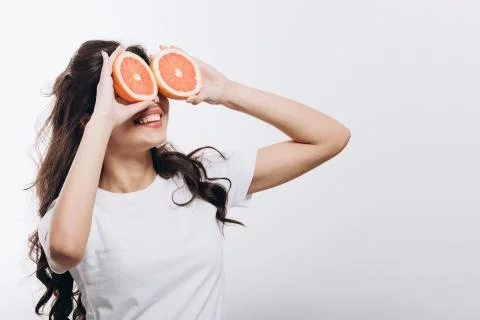 Cute Young Brunette Model Posing With Halves of Grapefruit Stock-Fotos