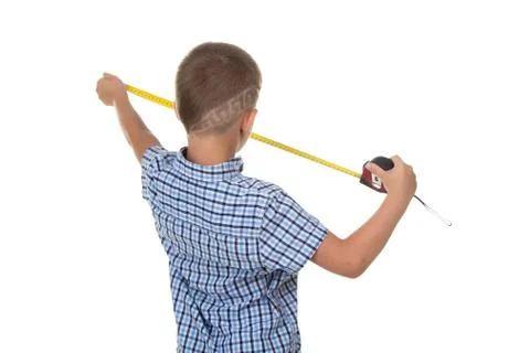 Cute young builder in blue checkered shirt measures something with a measuring Stock Photos