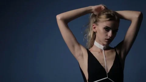 A cute young caucasian model posing for a fashion photographer in the studio. Stock Footage 81064363