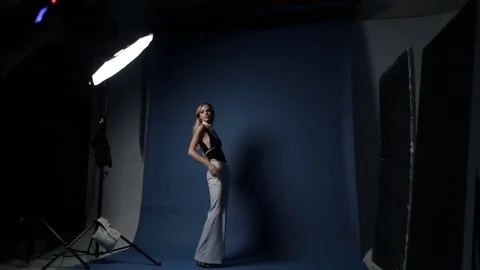 A cute young caucasian model posing for a fashion photographer in the studio. Stock Footage 81064404
