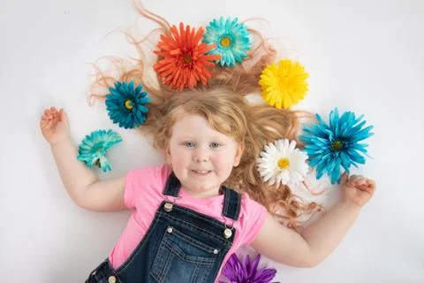 Cute young child laying down with floawers in her hair Stock Photos