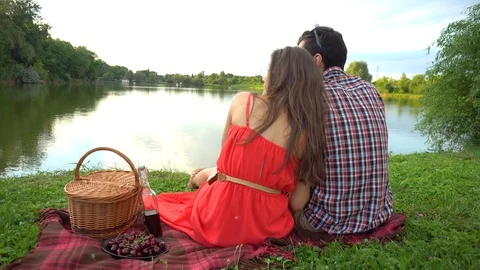 Cute young couple drinking red wine on a picnic in park near summer lake Video stock 109507063