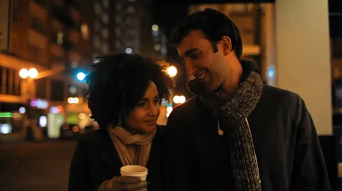 A cute young couple walk through a city at night together Stock Footage 34002606