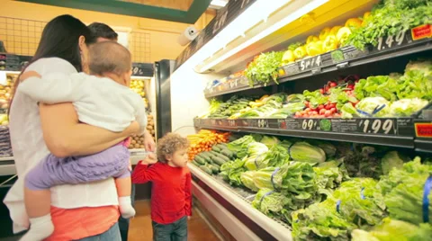 A cute young family pick out produce together in a grocery store Stock Footage 34004023