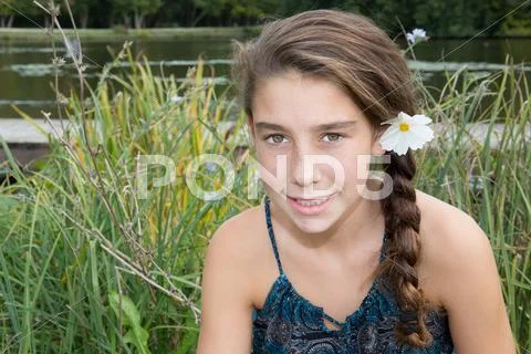 Cute young girl with a daisy in hair Stock Photos
