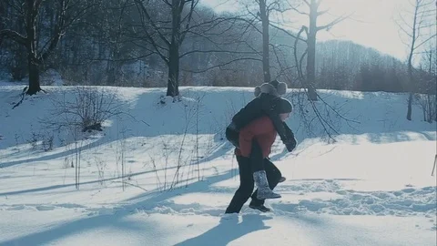 Cute young hipster couple having fun in winter park on a bright day hugging each Stockbeeldmateriaal 72410545