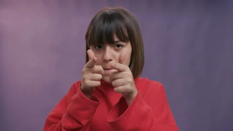 Cute young lady over isolated gray background wearing red dress pointing fingers Stock Footage 129339982