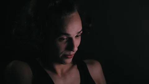 Cute young man using computer at home at night Видео 99931966