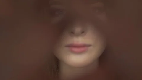 Cute young model poses for the camera. Closes the object with your hands. Stock Footage 99715331