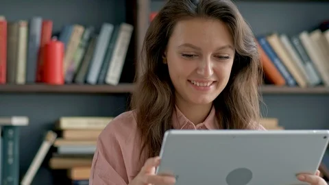 Cute young student using a tablet computer in a library Stock Footage 97553336