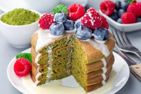 Cuted stack of matcha pancakes served with condensed milk, blueberry 스톡 사진