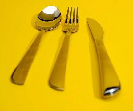 Cutlery on yellow background, close-up Stock Photos