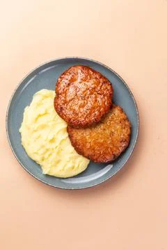 Cutlets and mashed potatoes in a plate on a light background. Stock Photos