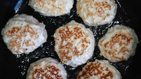 Cutlets are fried in a frying pan with oil. The camera shoots from above Stock Footage 150324406