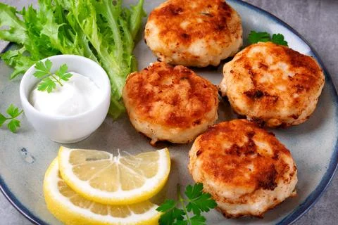 Cutlets with codfish and shrimps served with salad leaves Stock-Fotos