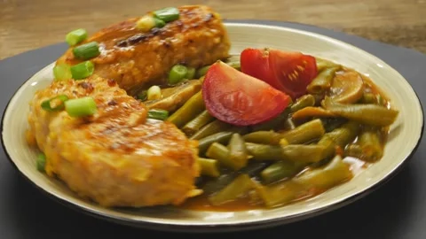 Cutlets with green beans and champignons in tomato sauce garnished 库存影片 220579499