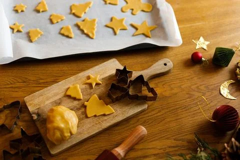 Cutout Star and Tree Cookie Dough Shapes arranged on Baking Sheet and Woode.. Stock Photos