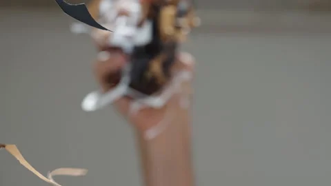Cutouts from colorful paper fall onto the table. Low angle view focus on glass Stock Footage 260975922