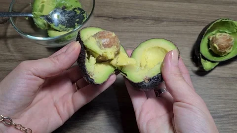 Cuts The Avocado In Half With Knife Stock Footage 166637246