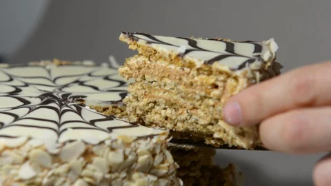 Cuts a beautiful holiday cake on the table. Tasty cake with nuts and cream Stock Footage 129038675
