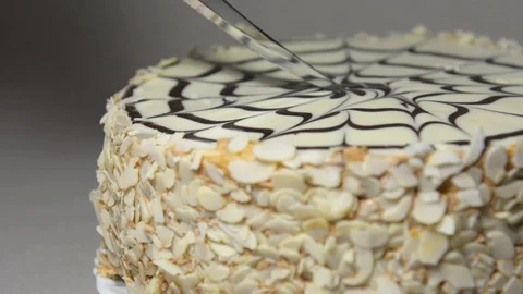 Cuts a beautiful holiday cake on the table. Tasty cake with nuts and cream Stock Footage 129038801